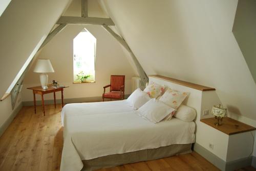 ein Schlafzimmer mit einem weißen Bett und einem Fenster in der Unterkunft Chambres d'Hôtes Le Château de la Plante in Thuré