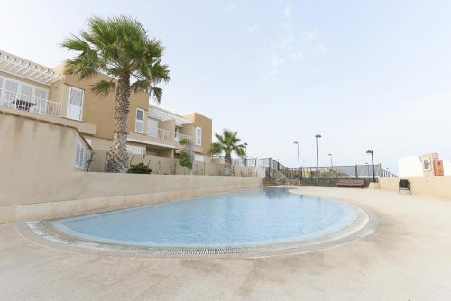 una piscina con palmeras y un edificio en Apartamento en Residencial cary 2., en Porís de Abona