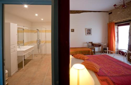 1 dormitorio con 1 cama y baño con lavamanos en La Bastide du Roy en Villamblard