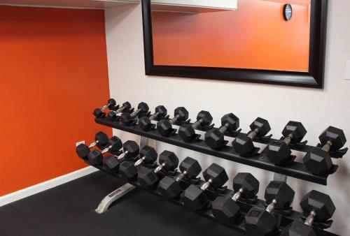 a gym with rows of dumbbells on the wall at Airport Honolulu Hotel, Trademark Collection by Wyndham in Honolulu