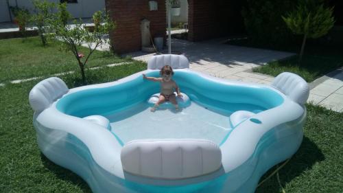 a woman is sitting in a pool in a backyard at Villa Juri Garden in Berat