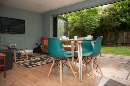 a dining room with a table and green chairs at Manor House London in London