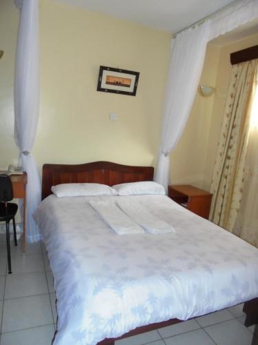 a bedroom with a bed with two towels on it at Adventist LMS Guest House & Conference Centre in Nairobi