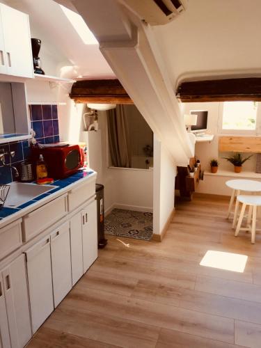 une cuisine avec des placards blancs et une salle à manger dans l'établissement Studio centre ville Cannes 200 mètres des plages du midi, à Cannes