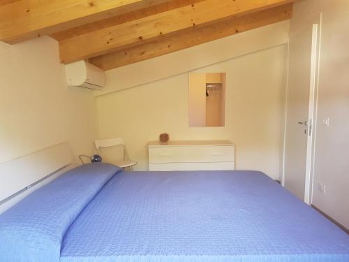 サンタ・マリア・デル・フォカッロにあるAppartamento Acaciaのベッドルーム1室(青いベッド1台、木製の天井付)