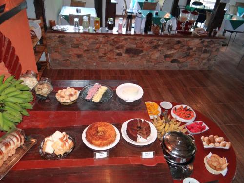 einen Tisch mit verschiedenen Arten von Lebensmitteln in der Unterkunft Pousada Banana Cipó in Serra do Cipo