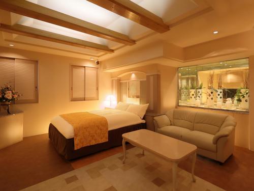 a hotel room with a bed and a couch at ホテルファインシエル出雲空港店 - 大人専用 in Izumo