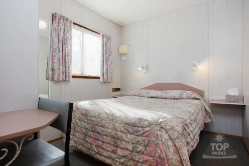 a hotel room with a bed and a desk at Horsham Holiday Park in Horsham