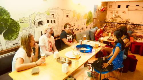 a group of people sitting at tables in a restaurant at ONE HOSTEL Himeji ワンホステル姫路 in Himeji