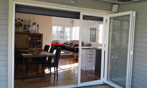 a sliding glass door leading into a dining room with a table at Peachgrove in Hamilton