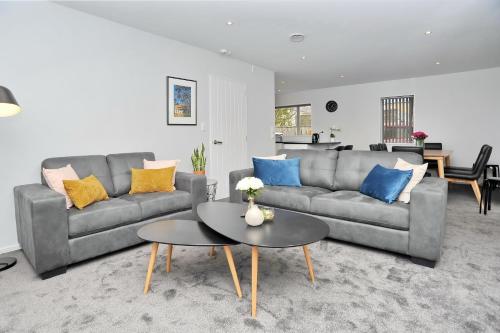 a living room with a couch and a table at Regents 94A - Christchurch Holiday Homes in Christchurch