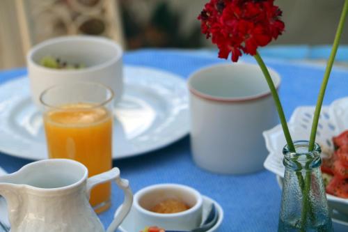 a blue table with a vase with a red flower in it at The Nest - A Romantic Vacation Home in Ein Kerem - Jerusalem in Jerusalem