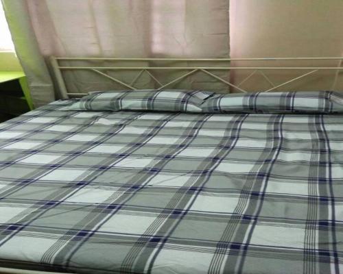 a bed with two pillows on top of it at Fleetwood Suites in Santo Tomas