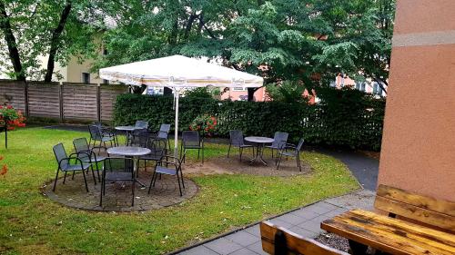 a group of tables and chairs under an umbrella at Hotel Amadeus Dresden Neustadt in Dresden