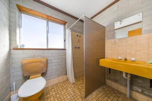 Un baño con inodoro, lavabo y ventana. en Nullarbor Roadhouse, en Nullarbor