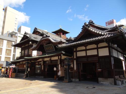 a building with a chinese roof on a street at Hotel Patio Dogo in Matsuyama