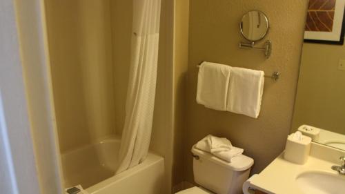 a bathroom with a white toilet and a sink at Hawthorn Suites Wichita East in Wichita