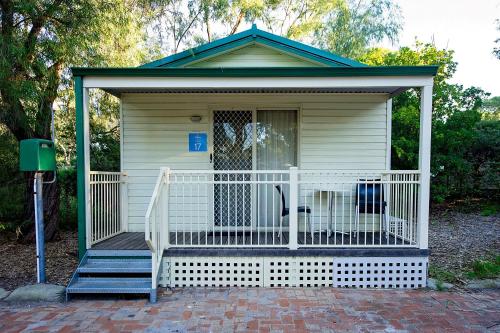 a dog sitting on the porch of a house at Discovery Parks - Woodman Point in Coogee