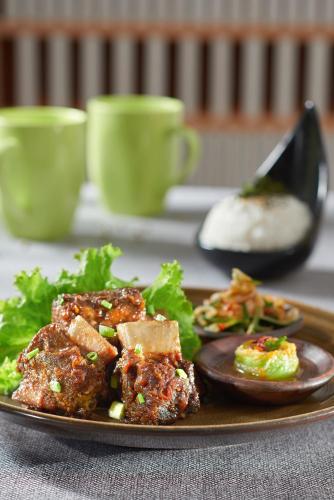 a plate of food on a table with some food at Golden Tulip Holland Resort Batu in Batu