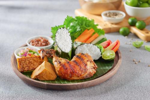 a plate of food with meat and vegetables on a table at Golden Tulip Holland Resort Batu in Batu