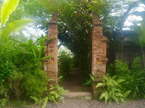 an archway in the middle of a garden at Bali Beach Eco Villas Pondok Matekap in Selemadeg