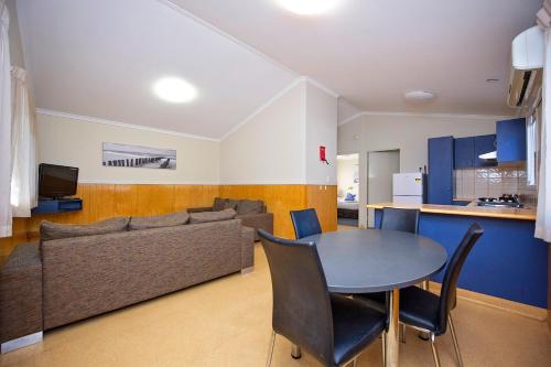 a living room with a table and a couch at Discovery Parks - Woodman Point in Coogee