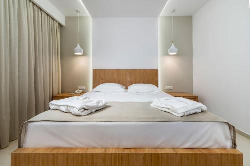 a bedroom with a large bed with towels on it at Gaia Palace in Mastichari