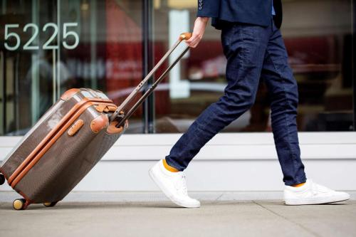 a person is pulling a suitcase on a sidewalk at Hyatt Place Salt Lake City Downtown / The Gateway in Salt Lake City