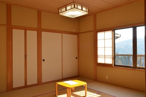 a room with a table and a window at Soratobu Usagi in Myoko