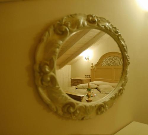 a mirror on a wall with a bed in a room at Theofilos Paradise Boutique Hotel in Mytilini