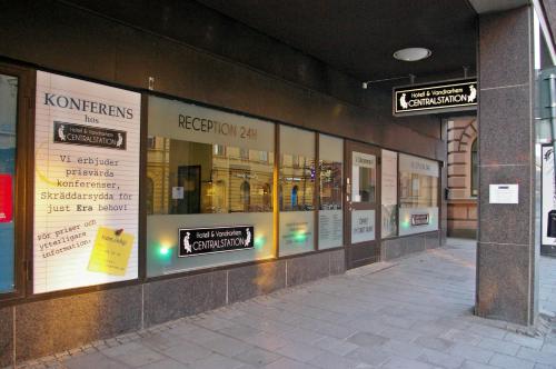 a store front with signs on the side of a building at Hotell Centralstation in Uppsala
