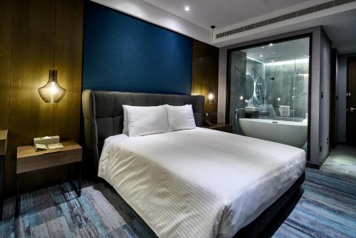 a bedroom with a large bed and a bath tub at Harbour 10 Hotel in Kaohsiung