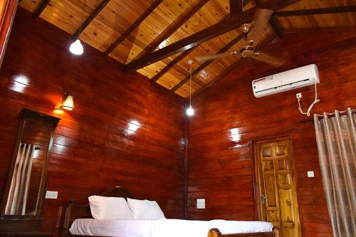 a bedroom with a wooden wall with a bed in it at Mithra Paradise Beach Hotel in Nilaveli
