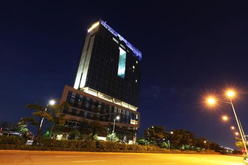 a tall building with lights on it at night at Bridge Hotel Incheon Songdo in Incheon