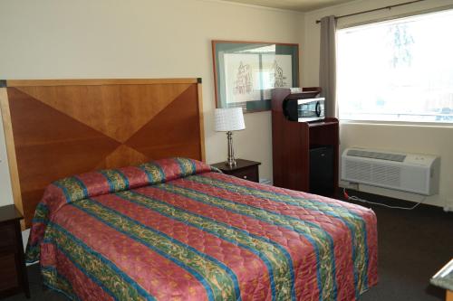 a hotel room with a bed and a television at River Park Inn in Klamath Falls