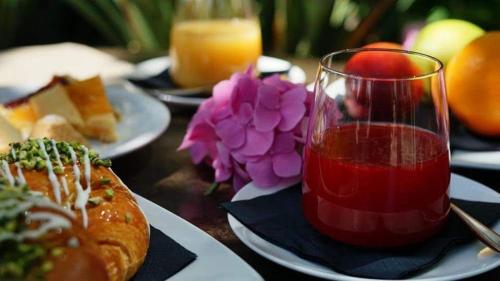 a table with plates of food and a glass of juice at Hotel Lady Mary in Milano Marittima