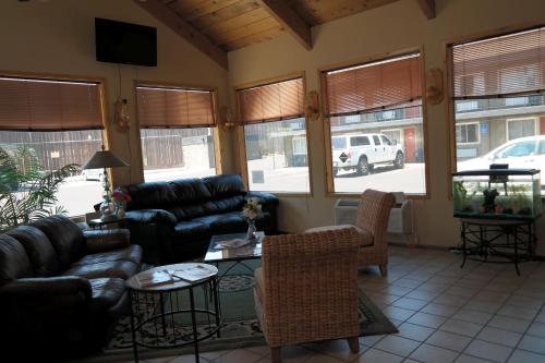 a living room with a couch and chairs and windows at River Park Inn in Klamath Falls
