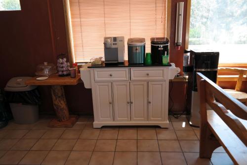 a kitchen with a white cabinet with a coffee maker on it at River Park Inn in Klamath Falls