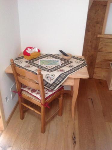 a table with a table cloth on top of a chair at Bed and Breakfast la Stube in Ziano di Fiemme