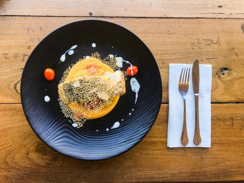 um prato preto de comida numa mesa com um garfo e uma faca em Hotel Northbridge em Perth