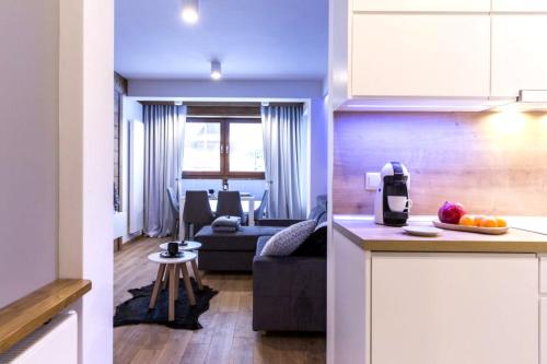 eine Küche und ein Wohnzimmer mit einem Sofa in der Unterkunft Polana Szymoszkowa Ski Resort- Koliba in Zakopane