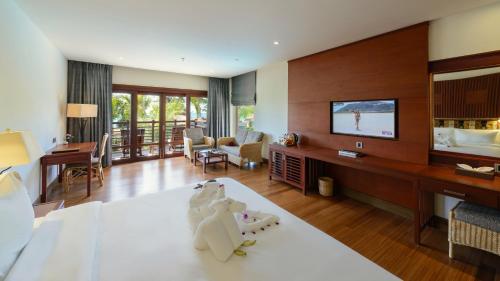 a living room with a television and a living room with a couch at The Haven Khao Lak - SHA Extra Plus in Khao Lak