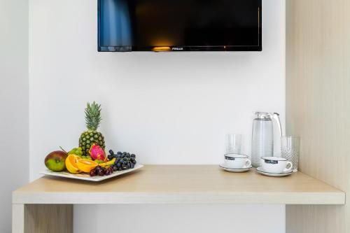 a table with a plate of fruit on it at Nymphes Deluxe Accommodation Pefkochori in Pefkohori