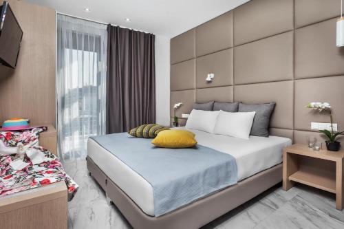 a bedroom with a large bed and a window at Nymphes Deluxe Accommodation Pefkochori in Pefkohori