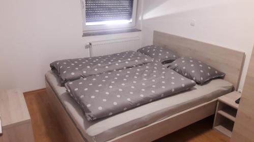 uma cama com almofadas de bolinhas num quarto em Gostilna Marta em Osluševci