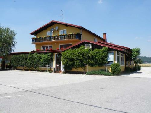 a large yellow building with a balcony at Gostilna Marta in Osluševci
