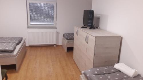 a room with two beds and a tv on a dresser at Gostilna Marta in Osluševci