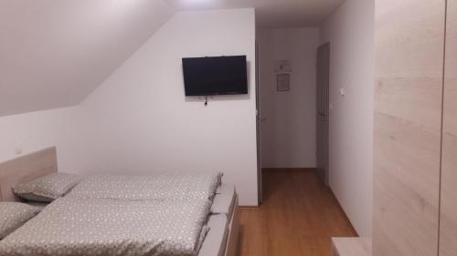 a bedroom with two beds and a flat screen tv at Gostilna Marta in Osluševci