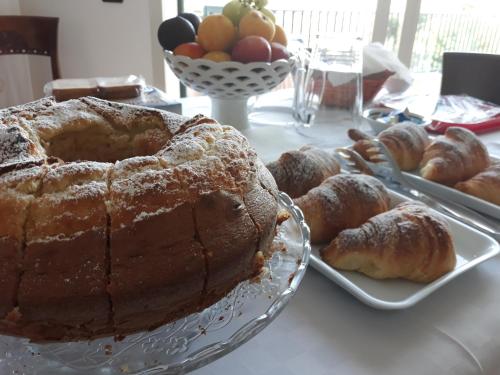 a table with a cake and pastries on a table at Villa Orchidea Luxury B&B in Ispica
