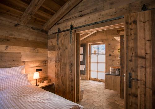 Una cama o camas en una habitación de Alpin Chalets Oberjoch - Luxus Unterkunft mit privatem SPA und Zugang zu 3000 qm SPA Panoramahotel Oberjoch